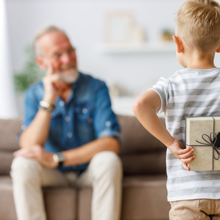 Petit garçon qui offre un cadeau à son grand-père
