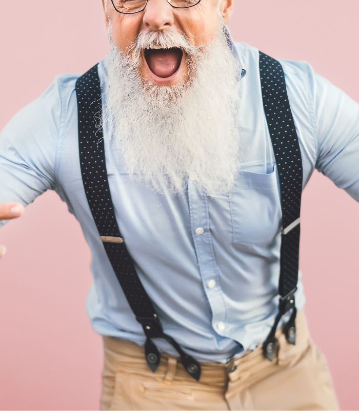 Homme agée avec une longue barbe souriant la bouche ouverte